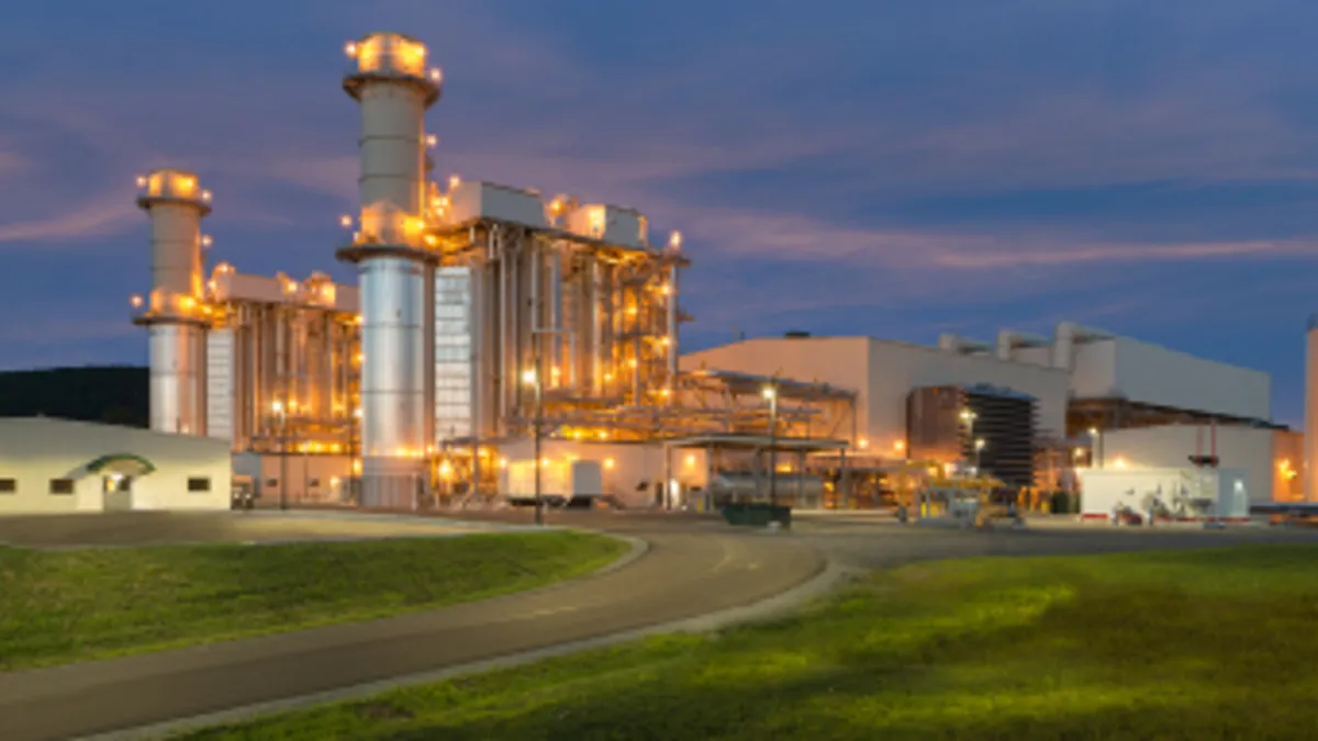 A gas-fired power plant at the edge of a field.