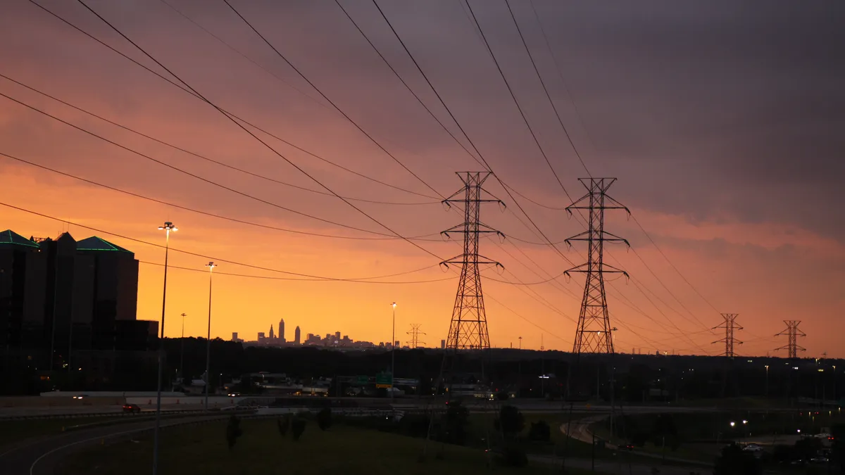 Power lines leading into the city of Cleveland Ohio at sunset time.