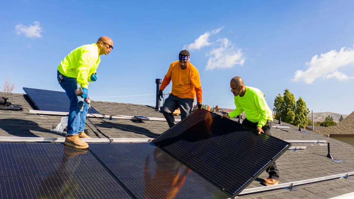 Team of workers install rooftop solar.