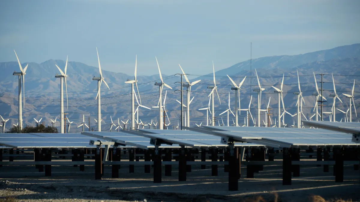 A picture of wind turbines in front of solar panels in Palm Springs, California.