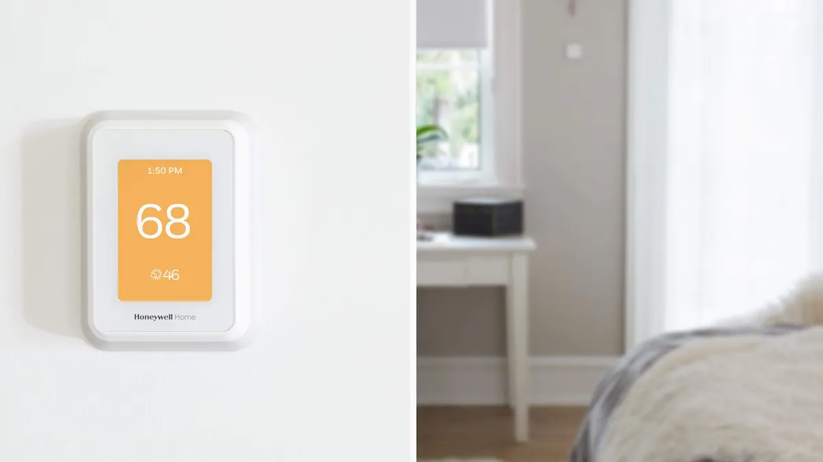 A Resideo smart thermostat mounted on a wall of a home.